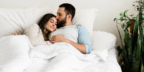 man and woman in bed cuddling